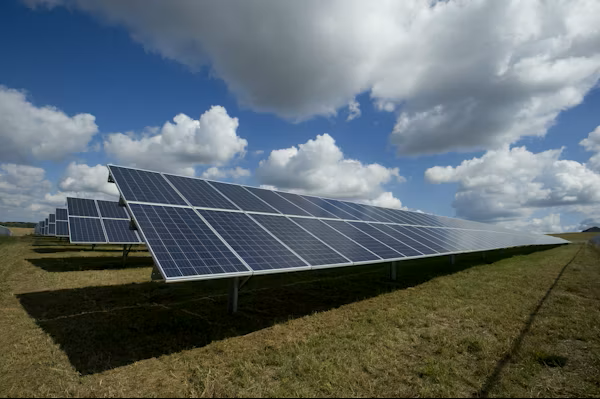 Solar panels on a field under a blue sky